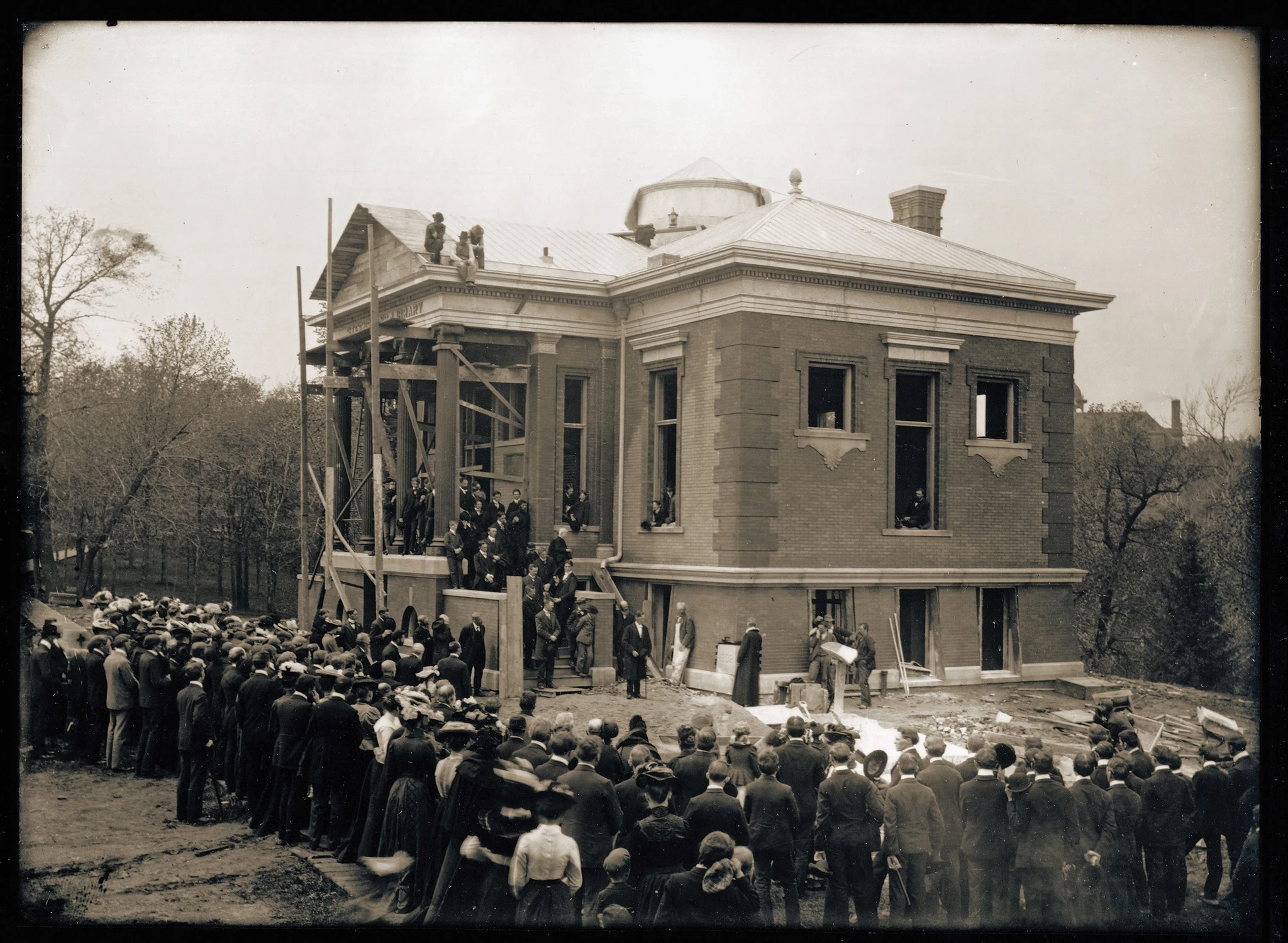 On May 17, 1902, photographer Ole G. Felland captured a large crowd watching the cornerstone ceremony for the Steensland Library.  St. Olaf College President John N. Kildahl (with cane) stands to the left of the cornerstone, and Nils J. Ellestad, Vice President of the United Church of Norway in America, stands to the right of the stone.  Photo courtesy of the St. Olaf Archives